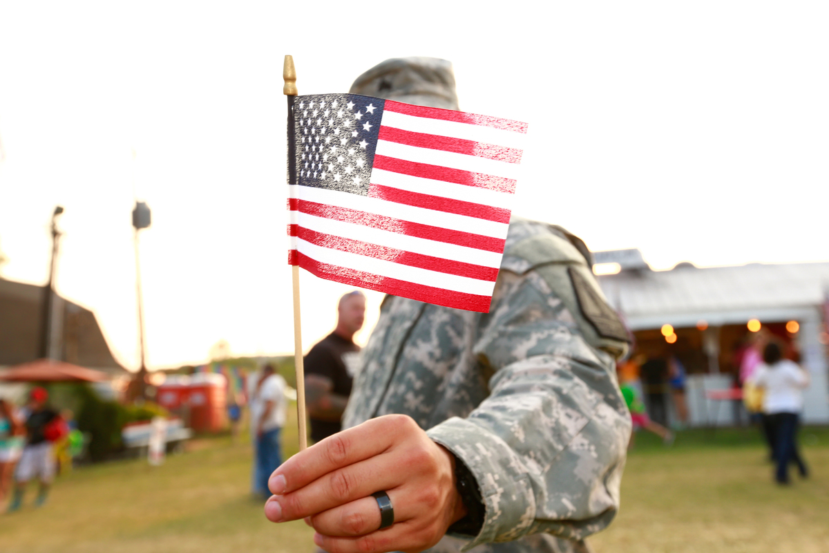 A U.S. veteran holds an American flag.