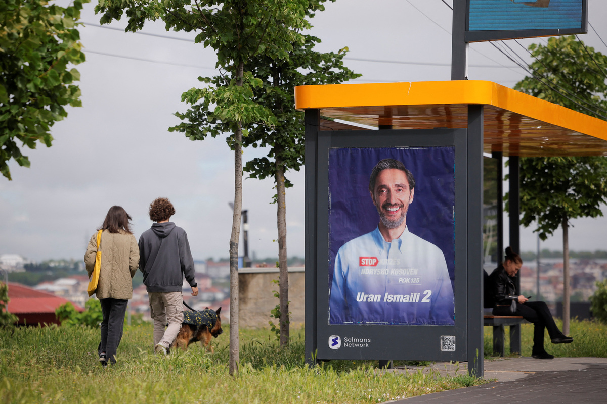 People walk past an election poster of the Democratic Party of Kosovo (PDK) in Pristina, Kosovo, June 4, 2026. Kosovo is to hold a snap parliamentary election, the third in just over a year, after parliament failed to elect a new head of state. REUTERS/Valdrin Xhemaj