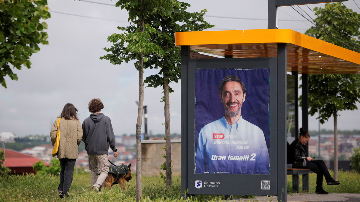 People walk past an election poster of the Democratic Party of Kosovo (PDK) in Pristina, Kosovo, June 4, 2026. Kosovo is to hold a snap parliamentary election, the third in just over a year, after parliament failed to elect a new head of state. REUTERS/Valdrin Xhemaj