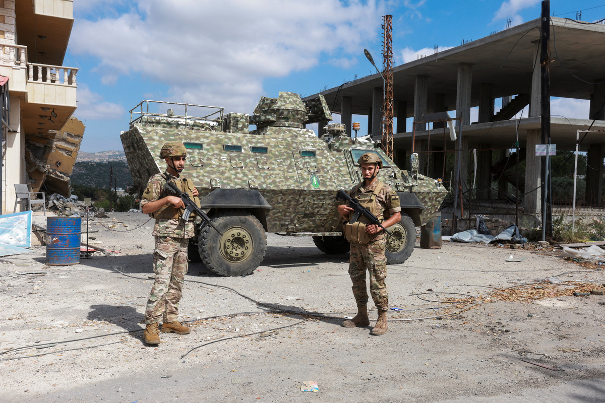 Members of the Lebanese army stand guard next to an armoured personnel carrier, as people make their way back to their homes, following a peace deal between the United States and Iran, in Bir Al-Salasil, Tyre district, southern Lebanon, June 15, 2026. REUTERS/Aziz Taher