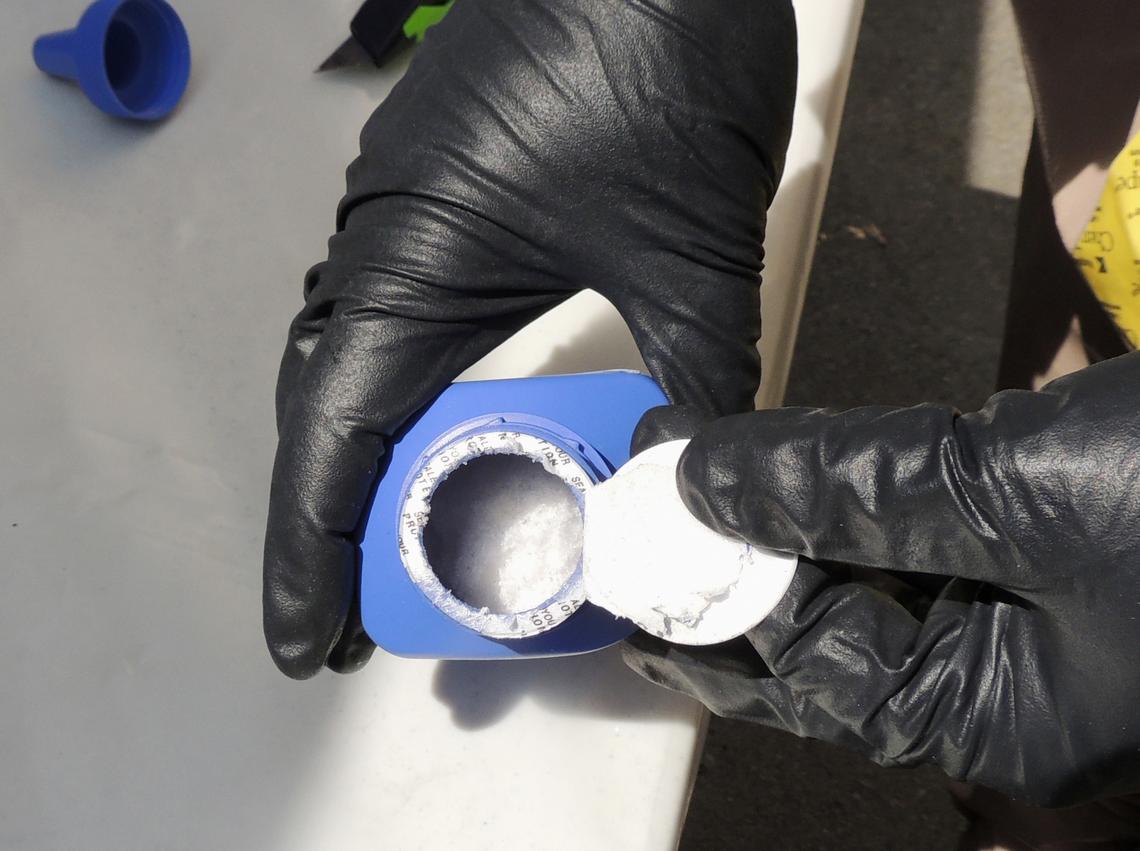  A 2016 photo provided by the Royal Canadian Mounted Police, a member of the RCMP opens a printer ink bottle containing the opioid carfentanil imported from China, in Vancouver. 