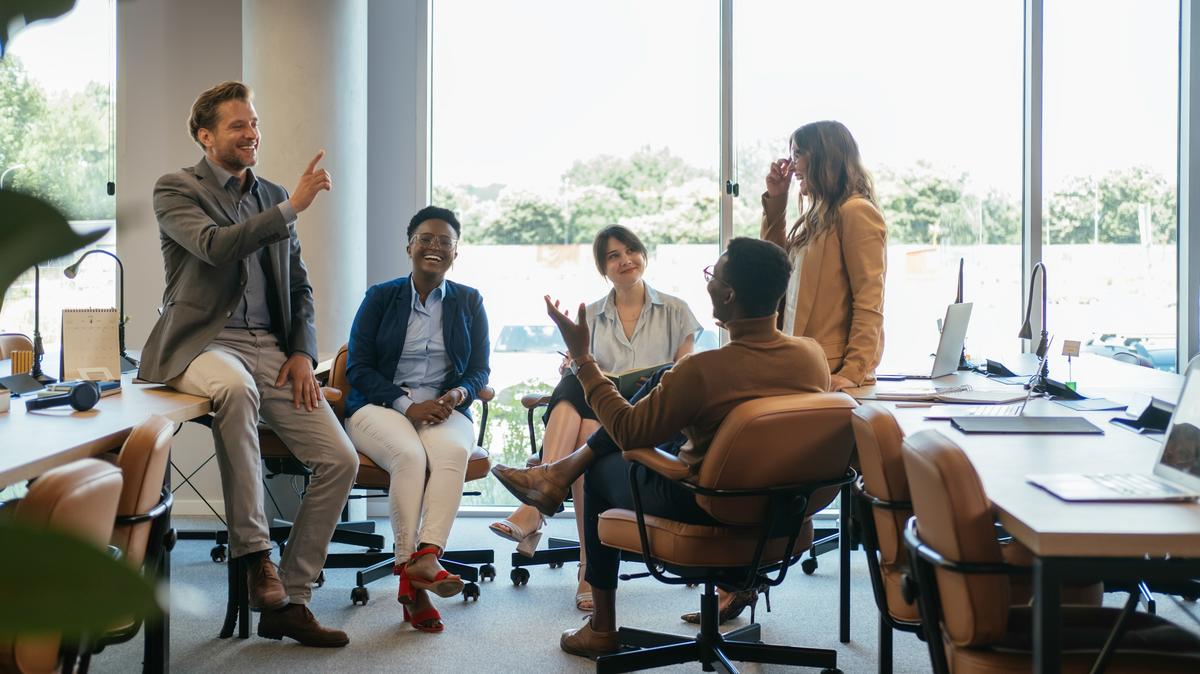 Five employees sit together in an office. 