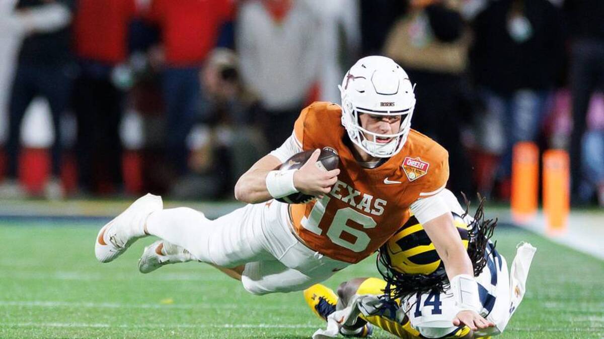  Dec 31, 2025; Orlando, FL, USA; Texas Longhorns quarterback Arch Manning (16) reaches with the ball for a first down while Michigan Wolverines defensive back Jordan Young (14) attempts to tackle during the second half at Camping World Stadium. Mandatory Credit: Matt Pendleton-Imagn Images | Matt Pendleton-Imagn Images 