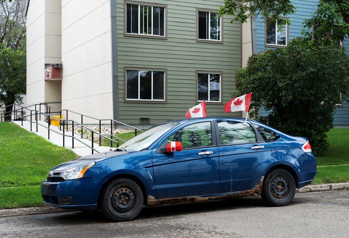 A car is parked adorney with Canadian flags, as Alberta separatists set up an information booth nearby at the Ponoka Stampede, in Ponoka, Alberta, Canada, June 27, 2026.  REUTERS/Todd Korol