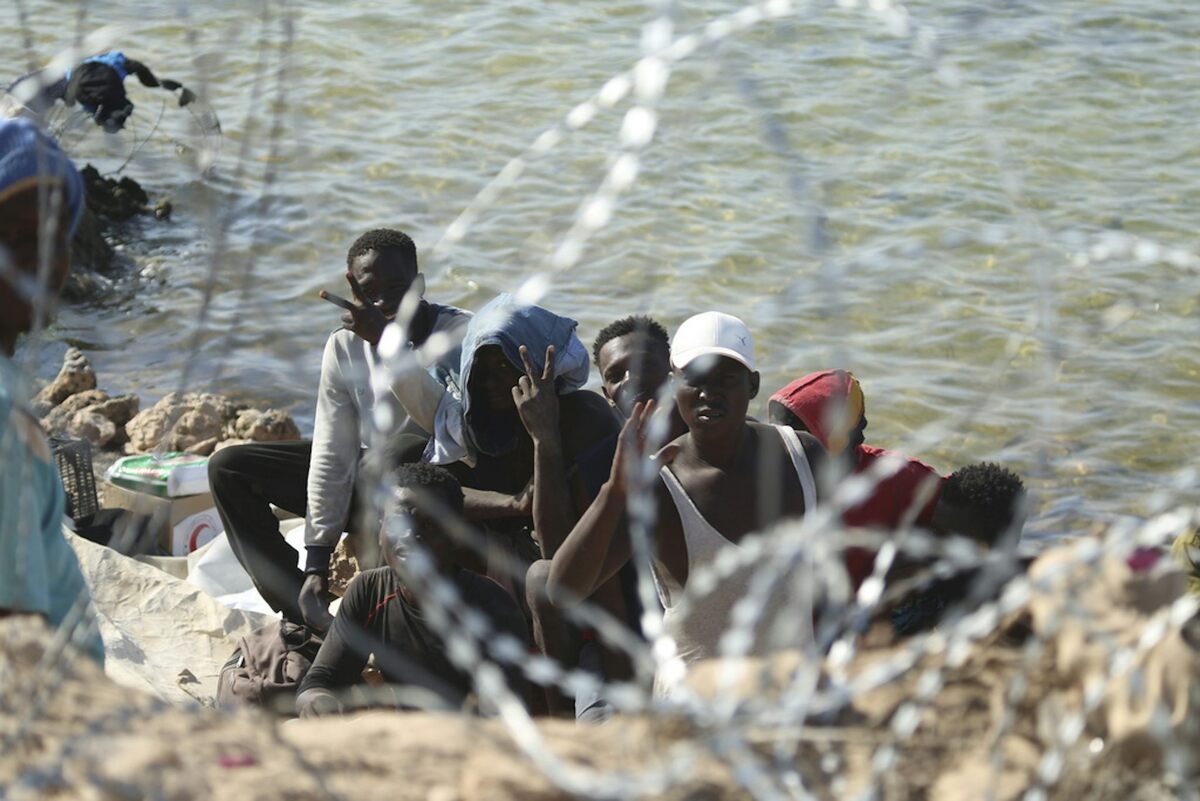  Migrants gather in an area near the Libyan-Tunisia border, as Libyan security forces and Libyan Red Cross workers distribute food aid to them. AP Photo/Yousef Murad 