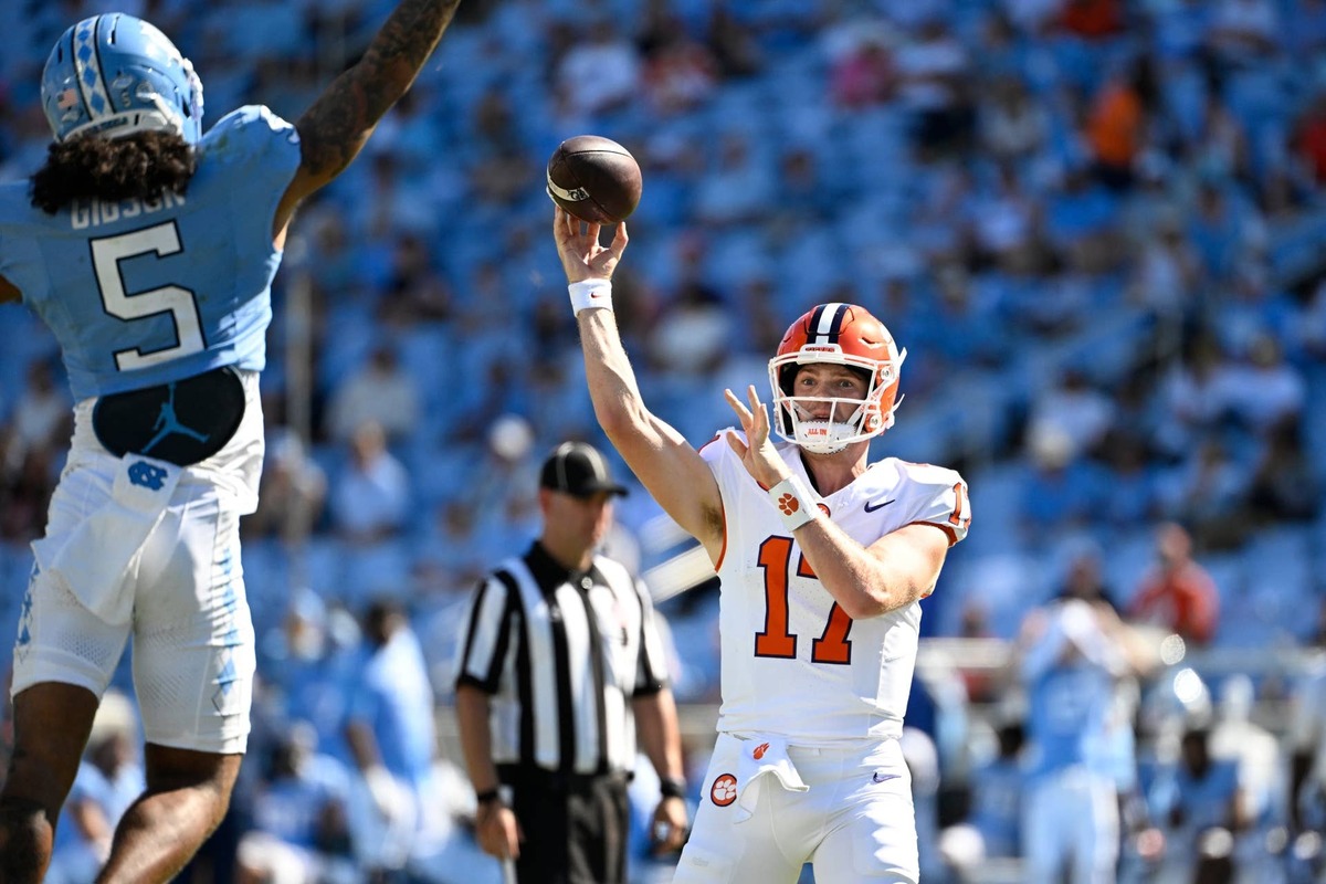  Oct 4, 2025; Chapel Hill, North Carolina, USA; Clemson Tigers quarterback Christopher Vizzina (17) passes the ball as North Carolina Tar Heels defensive back Gavin Gibson (5) pressures in the fourth quarter at Kenan Stadium. Mandatory Credit: Bob Donnan-Imagn Images