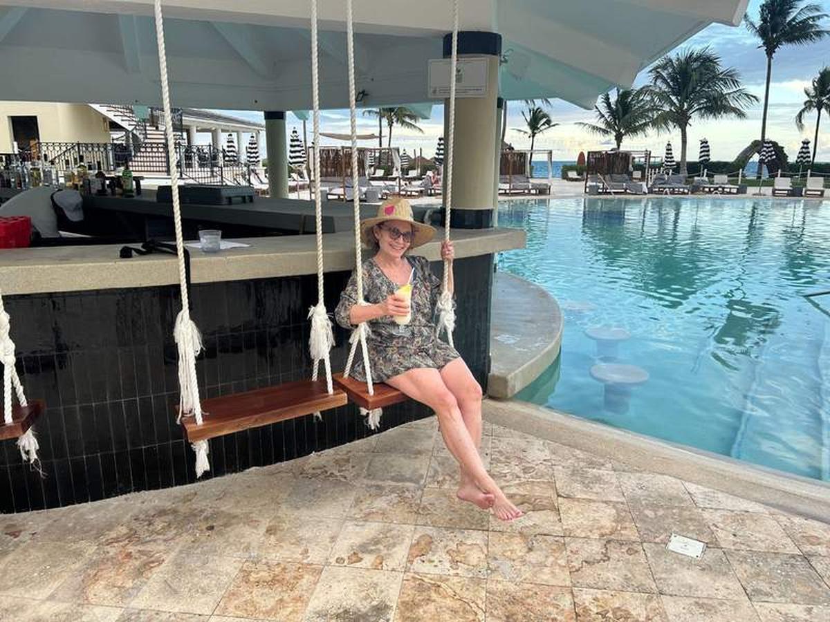  The writer enjoying the low-key vibe with a frosty pina colada on the swing seats at the swim-up bar. Photo credit: Bethany Kandel 