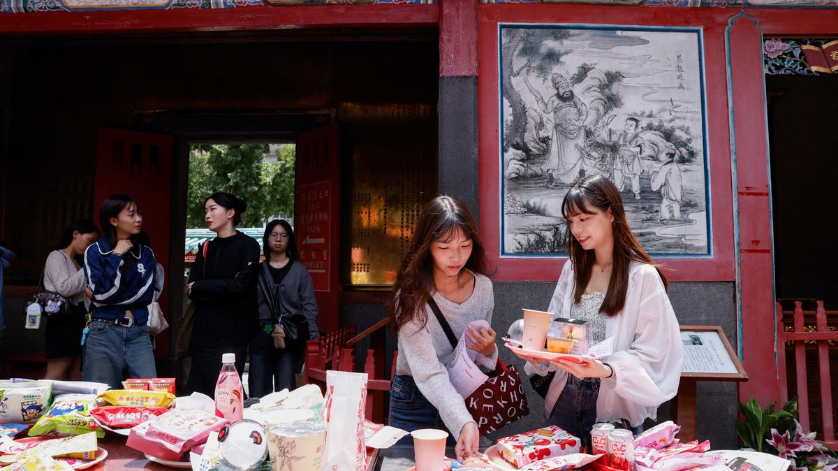 K-pop fans, mostly BTS fans, lay out snacks, group merchandise, concert seat maps and wish lists on an altar table as they pray to Yue Lao, the god of love in Chinese mythology who oversees relationships and marriage, at Taipei’s Bangka Lungshan Temple, in hopes of securing a concert ticket, in Taipei, Taiwan, May 30, 2026. REUTERS/Ann Wang