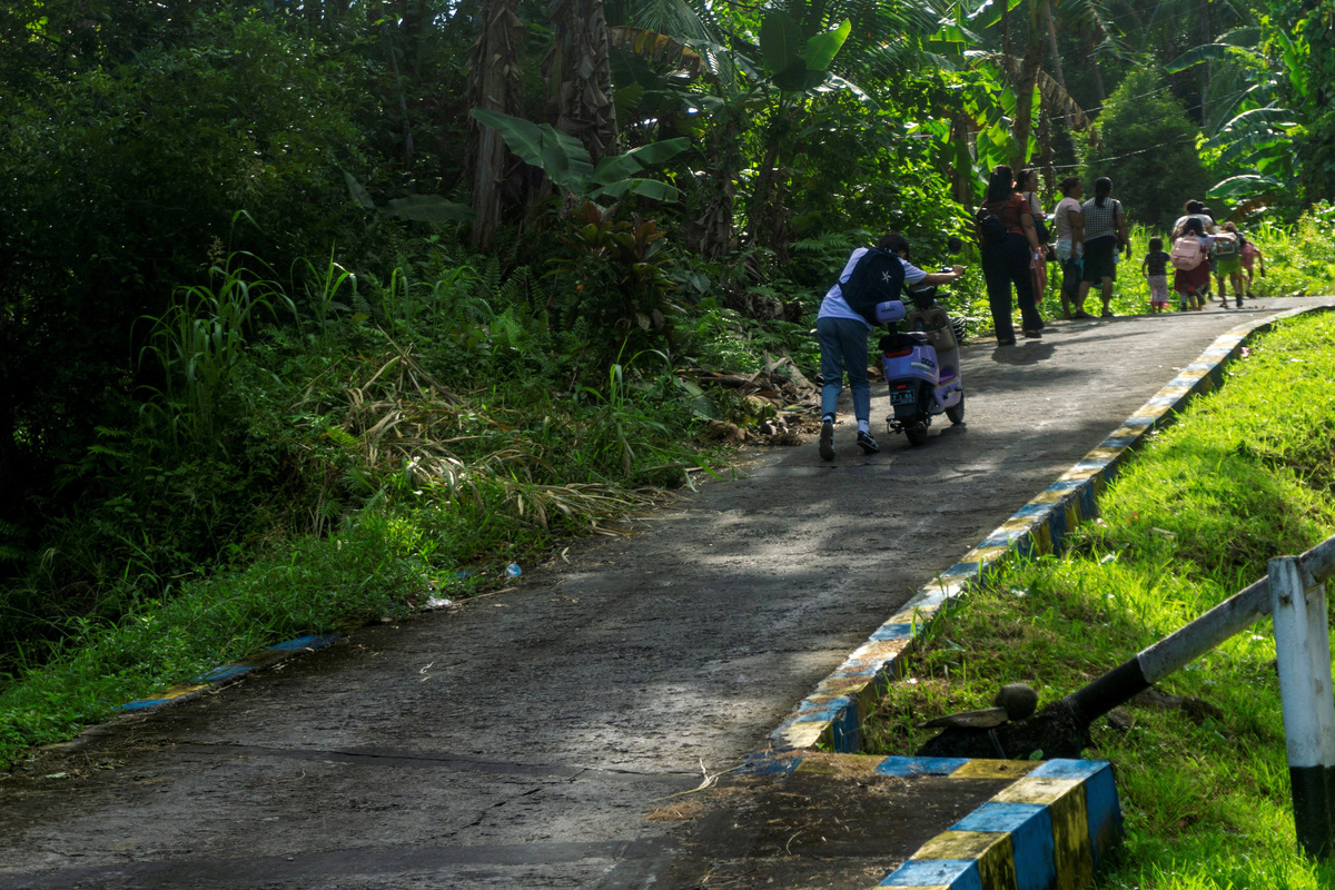 People walk as they evacuate to the highlands after Indonesia’s geophysics agency issued a tsunami warning following an earthquake off the southern Philippine island of Mindanao that was also felt in Tahuna, Sangihe Islands regency, North Sulawesi province, Indonesia, on Monday.