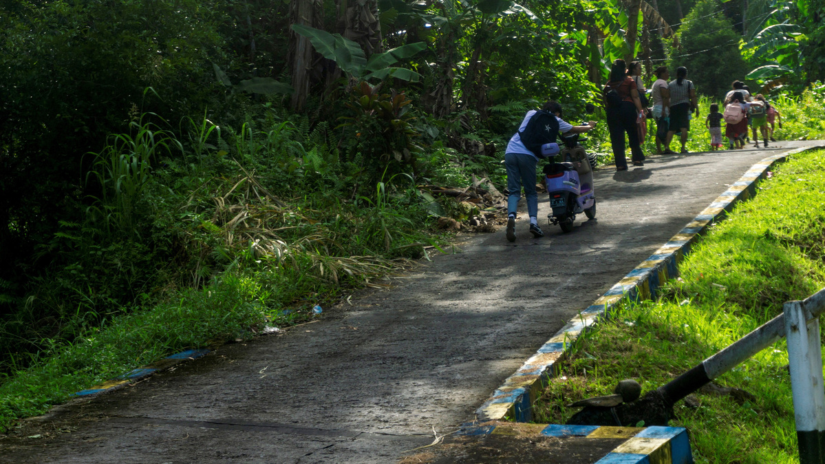 People walk as they evacuate to the highlands after Indonesia’s geophysics agency issued a tsunami warning following an earthquake off the southern Philippine island of Mindanao that was also felt in Tahuna, Sangihe Islands regency, North Sulawesi province, Indonesia, on Monday.