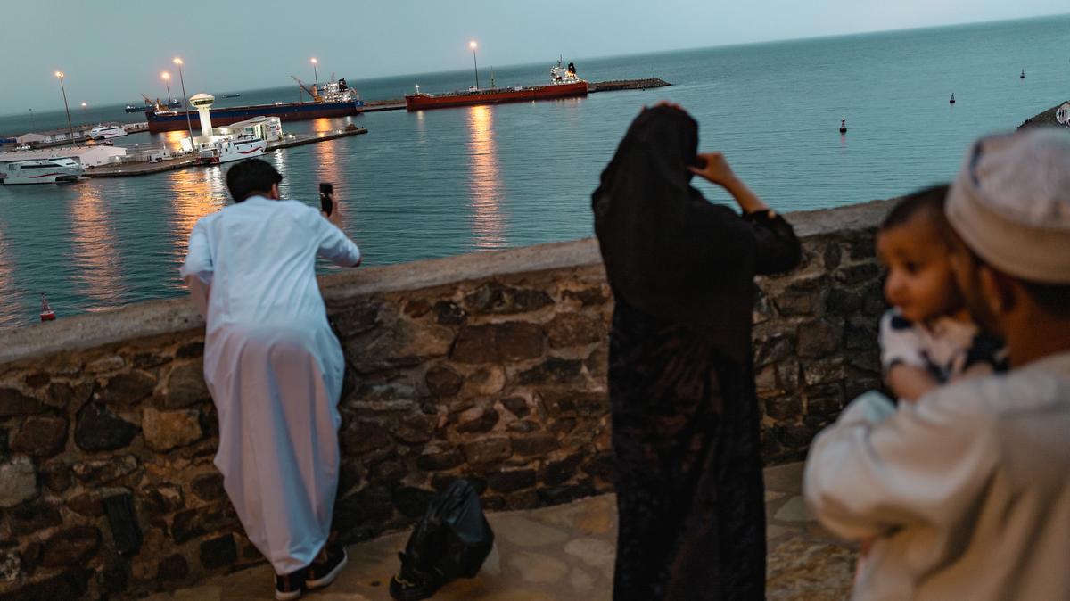 Locals take photos of two bulk carriers anchored at Muscat Anchorage in Muscat, Oman, on March 25, as maritime traffic through the Strait of Hormuz, which conveys about 20% of the world's oil and gas, has mostly come to a halt after the joint U.S.-Israeli war with Iran that began on Feb. 28.