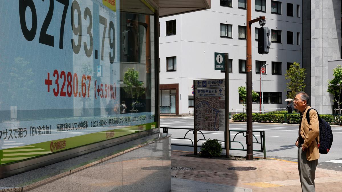 A pedestrian looks at a stock quotation board showing the Nikkei share average outside a brokerage in Tokyo, Japan, May 7, 2026. REUTERS/Kim Kyung-Hoon