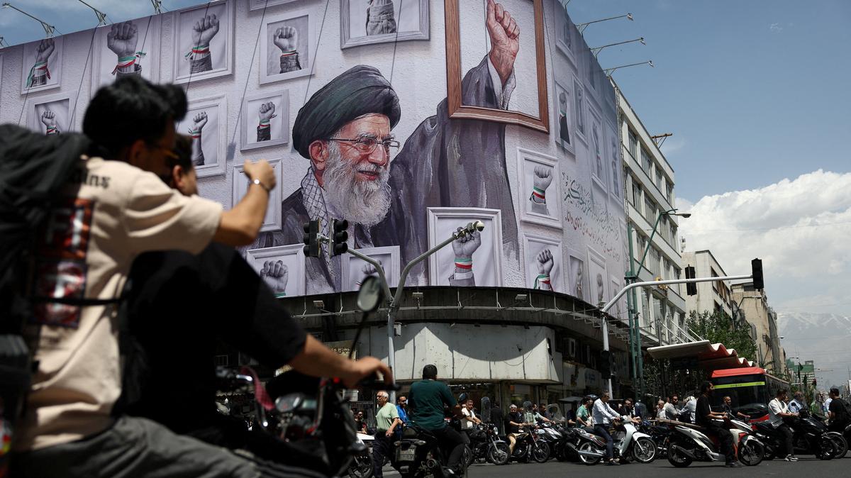 People ride motorcycles near a billboard featuring an image of the late Supreme Leader of Iran, Ayatollah Ali Khamenei, in Tehran, Iran, May 6, 2026. Majid Asgaripour/WANA (West Asia News Agency) via REUTERS