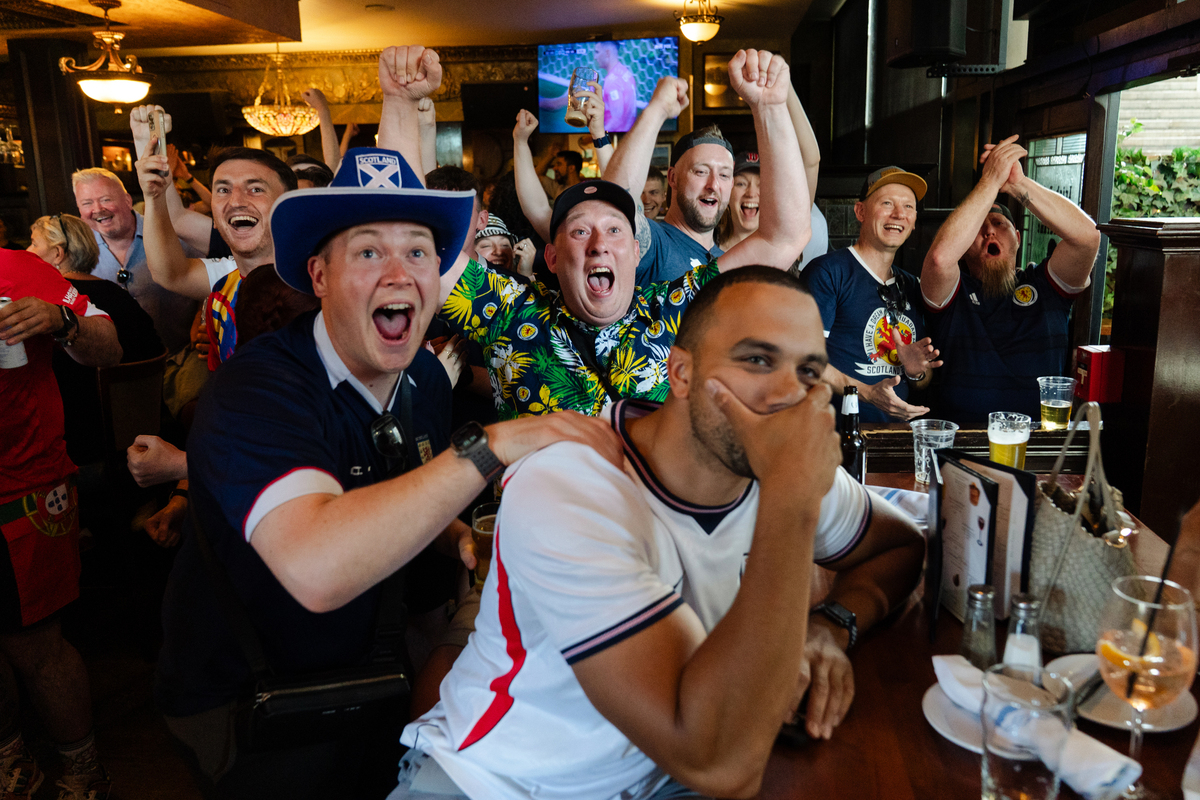 A Scotland soccer fan, center in floral shirt, celebrates Croatia's goal during a World Cup game against England at The Dubliner Irish pub in Boston on June 17, 2026. The Tartan Army -- thousands of soccer fans from Scotland, here to see their national team play outside Boston in two matches of the World Cup -- are packing this old city's narrow streets, its subway cars, restaurants and pubs, and filling the air with the cry of bagpipes. (Sophie Park/The New York Times)