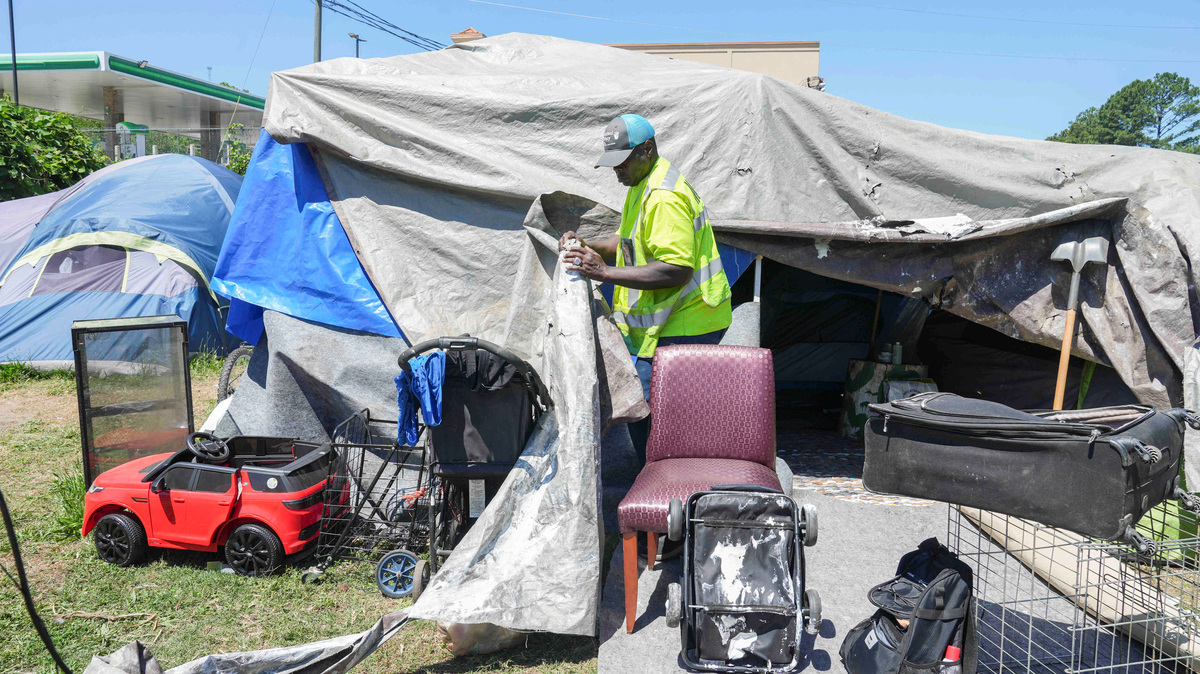 Benjamin Brown, 54, who is currently experiencing homelessness, opens up the tarps to show the inside of his tent in Atlanta, Georgia, U.S., May 15, 2026.   REUTERS/Megan Varner