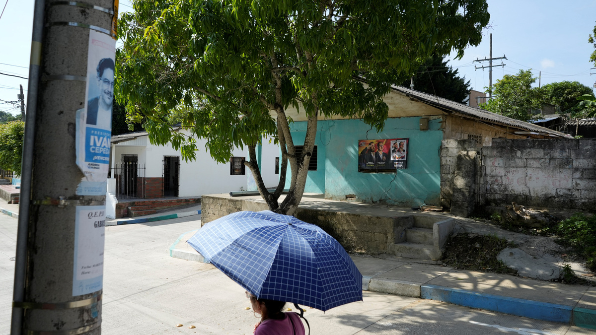 A woman walks past electoral advertisements ahead of the 21 June runoff between right-wing presidential candidate Abelardo De La Espriella and leftist candidate Ivan Cepeda, in Tubara, Colombia, June 10, 2026. REUTERS/Charlie Cordero