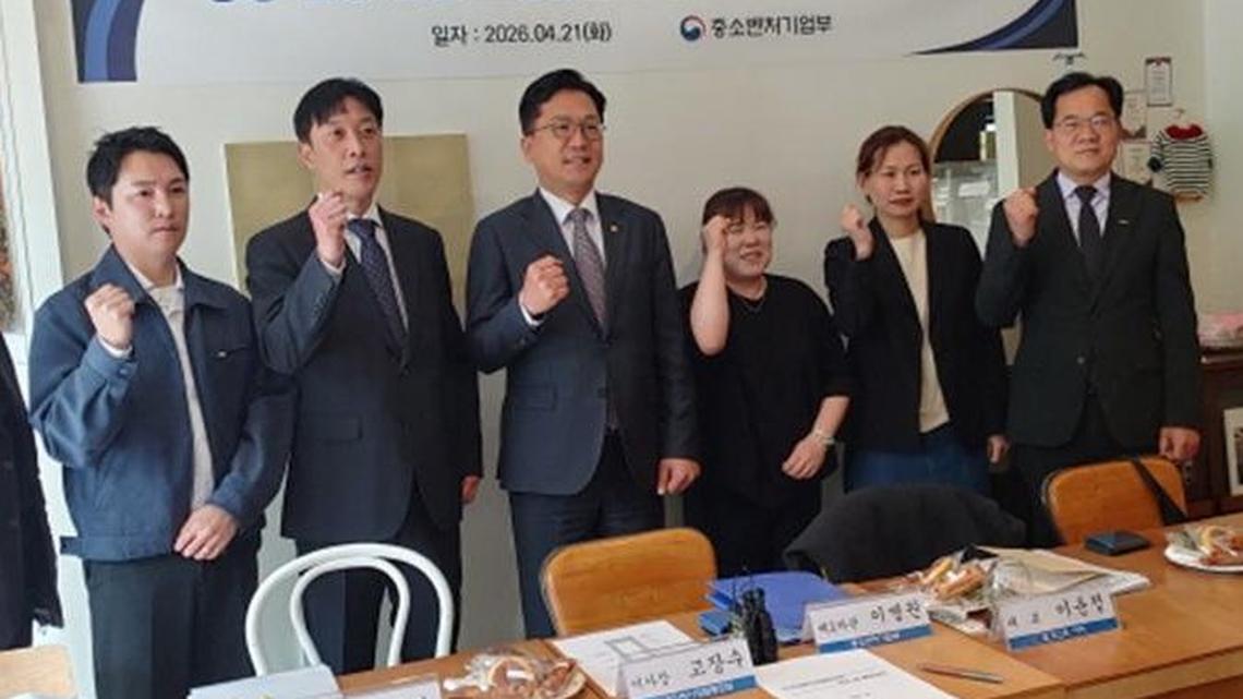 Lee Byung-kwon, fourth from left, second vice minister of SMEs and Startups,
poses with cafe owners during a meeting at a cafe in Seoul on Monday. Photo by Asia
Today