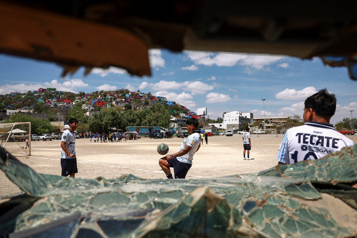 'Pandilleros' team members are seen warming up through a broken car window ahead of the Cerro de la Campana llanero soccer championship semifinal against 'Bandoleros' at Los Pinos football pitch in Monterrey, Mexico, March 29, 2026. REUTERS/Raquel Cunha            SEARCH "CUNHA MEXICO SOCCER" FOR THIS STORY. SEARCH "WIDER IMAGE" FOR ALL STORIES.          TPX IMAGES OF THE DAY