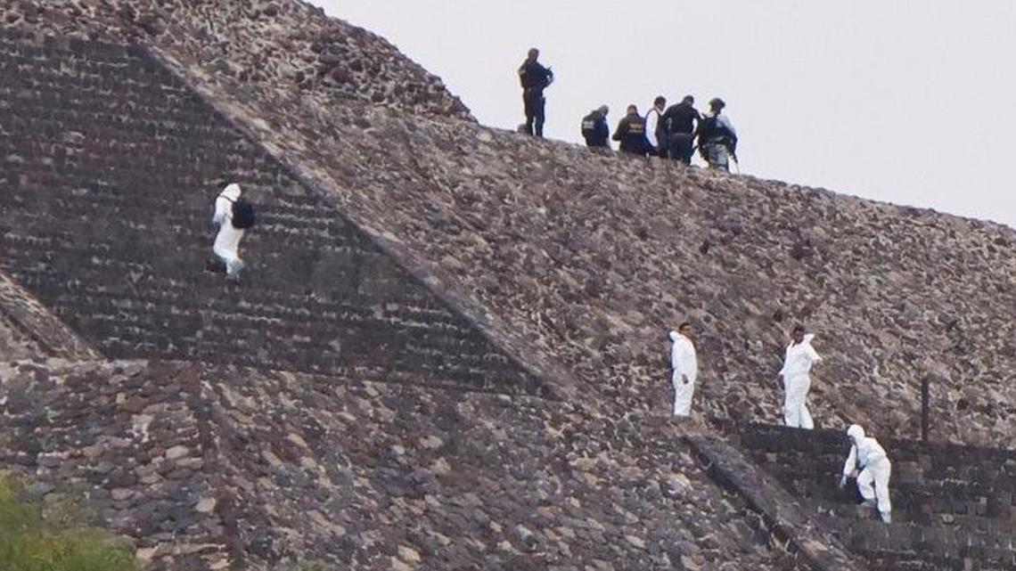 Police officers and forensic experts secure the area where a shooting occurred at the Teotihuacan archaeological site in Mexico on Monday. One tourist was killed and 13 were wounded. The gunman died of a self-inflicted wound.
