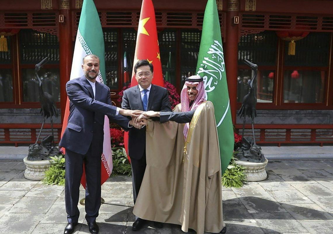  China's former foreign minister looks on as Iranian and Saudi diplomats shake hands during Beijing-mediated talks in 2023. Iranian Foreign Ministry via AP 