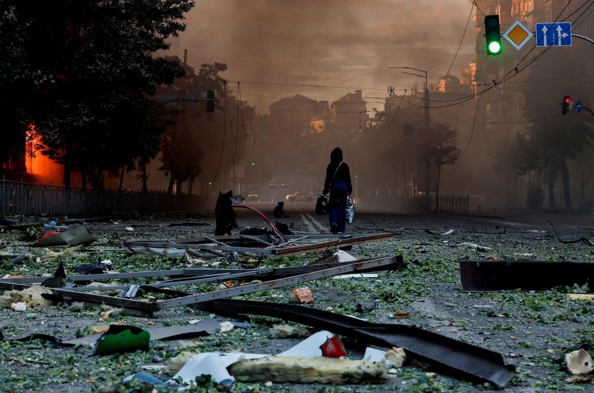 A person walks on a debris-scattered street in the aftermath of an overnight Russian missile and drone strike, amid Russia's attack on Ukraine, in Kyiv, Ukraine, May 24, 2026. REUTERS/Thomas Peter