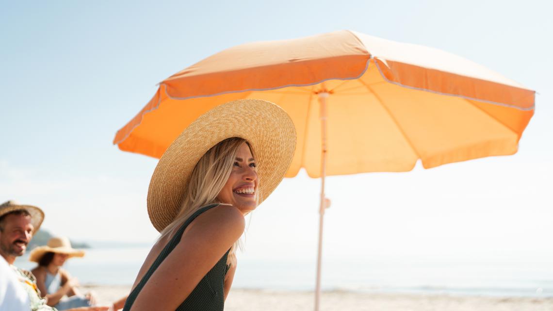 Photo of a young women who is relaxing on a hot summer day by the sea, accompanied by her closest friends