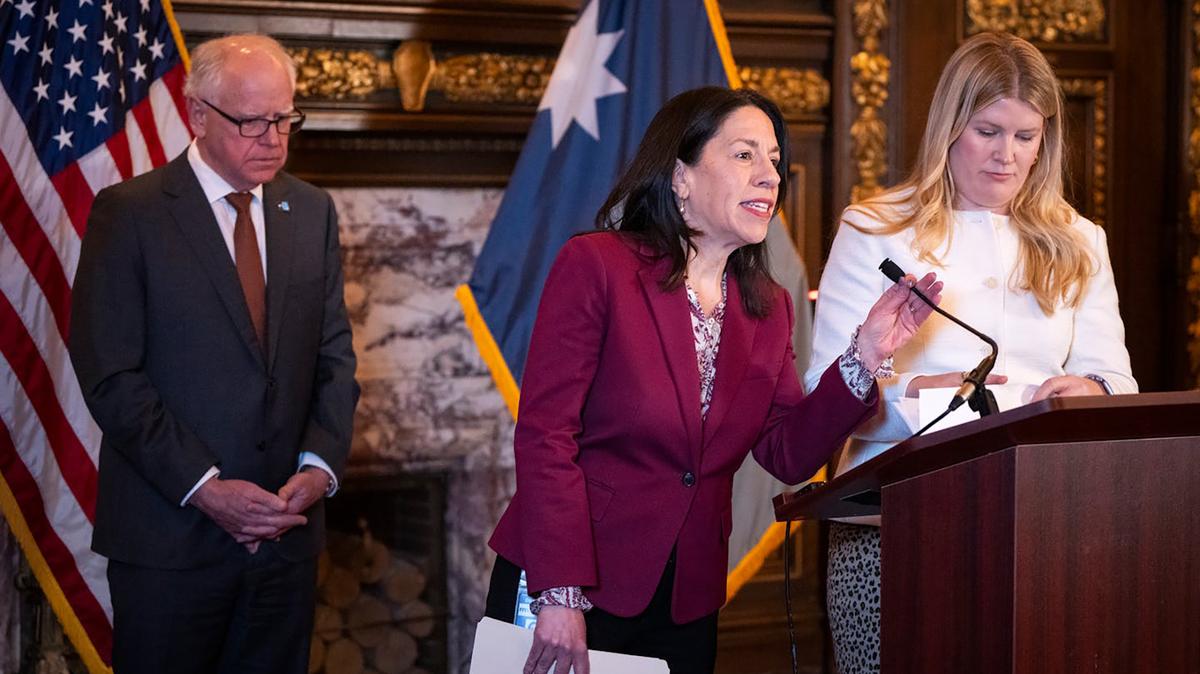 DHS Commissioner Shireen Gandhi speaks, with Minnesota Gov. Tim Walz, left, and State Budget Director Ahna Minge, right, during a March 2026 news conference in St. Paul Minnesota. (Leila Navidi/The Minnesota Star Tribune/TNS)