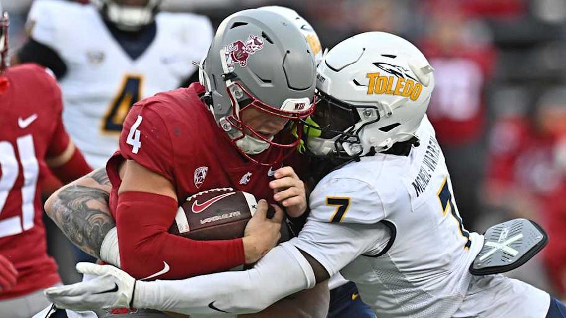  Oct 25, 2025; Pullman, Washington, USA; Washington State Cougars quarterback Zevi Eckhaus (4) is tackled by Toledo Rockets safety Emmanuel McNeil-Warren (7) in the second half at Gesa Field at Martin Stadium. Mandatory Credit: James Snook-Imagn Images | James Snook-Imagn Images 
