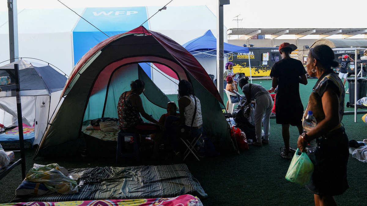 People gather near their tents at a makeshift shelter run by the United Nations at the Jose Maria Vargas Sports Complex, in the aftermath of the June 24 earthquakes, in La Guaira, Venezuela, on Tuesday. Authorities raised the death toll on Thursday to 3,889.