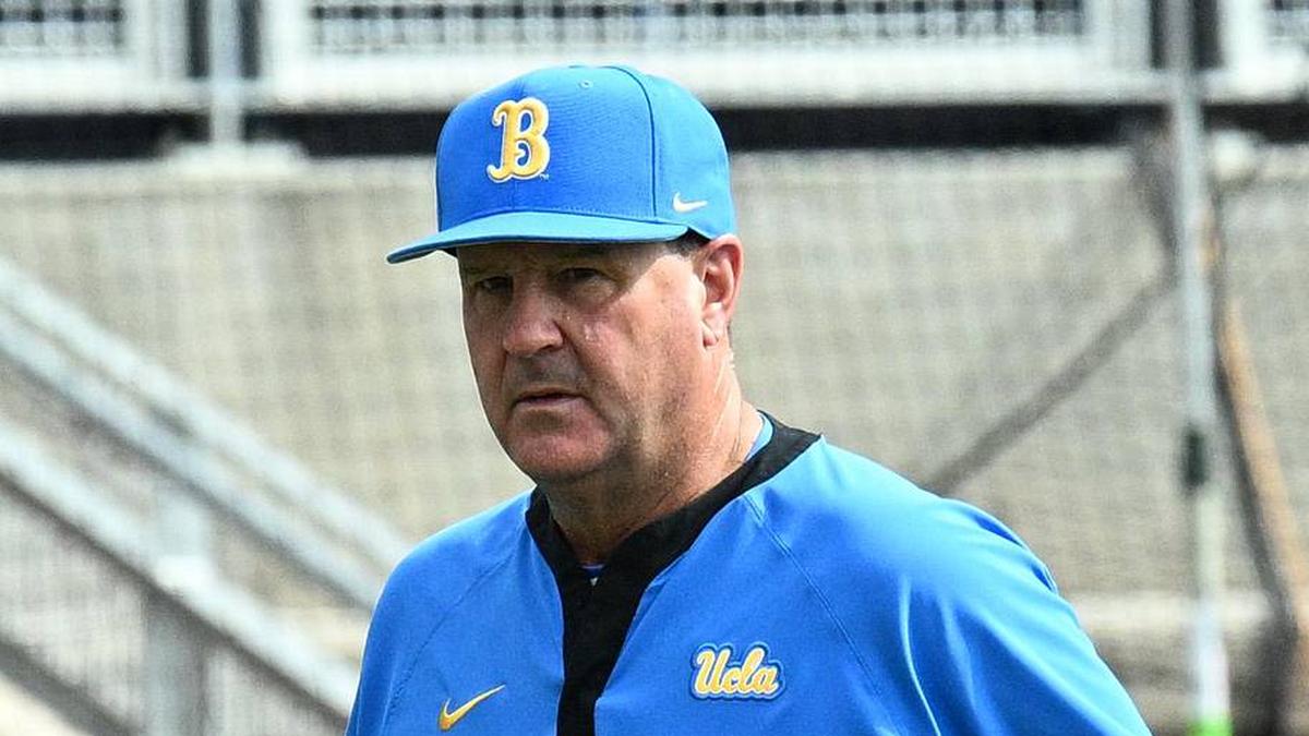  Jun 17, 2025; Omaha, Neb, USA; UCLA Bruins head coach John Savage (22) walks to the dugout before the restart of the game against the LSU Tigers at Charles Schwab Field. Mandatory Credit: Steven Branscombe-Imagn Images | Steven Branscombe-Imagn Images 