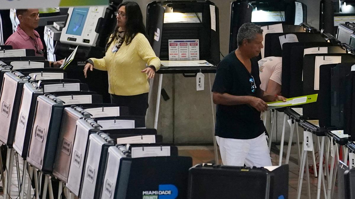 Un trabajador electoral dirige a los electores en un centro de votación anticipada el 31 de octubre de 2022 en Miami.