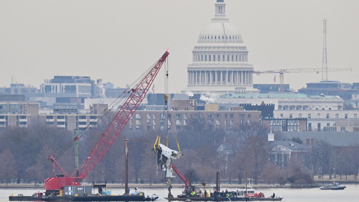 A crane removes airplane wreckage from the Potomac River, where American Airlines flight 5342 collided with a U.S. Army military helicopter, near Ronald Reagan Washington National Airport in Arlington, Virginia, on Feb. 3, 2025. (Roberto Schmidt/AFP/Getty Images/TNS)