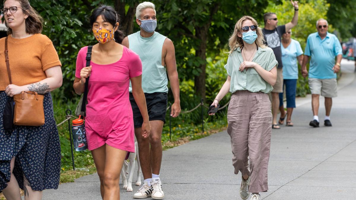 Madeline Raskay (der.) y Aldany Diaz (tercera de izq. a der.), usan mascarillas a pesar de estar vacunadas, durante su caminata en el vecindario Old Fourth Ward de Atlanta, el viernes 14 de mayo de 2021.