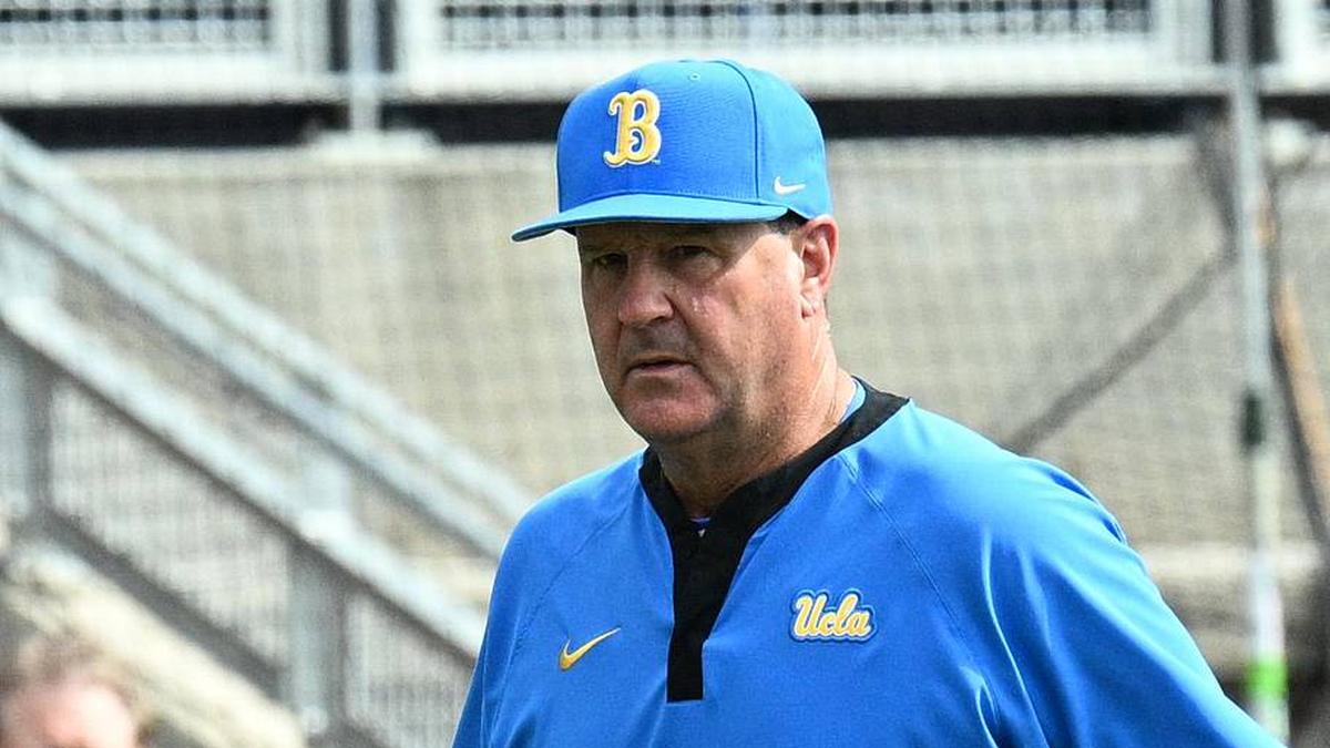  Jun 17, 2025; Omaha, Neb, USA; UCLA Bruins head coach John Savage (22) walks to the dugout before the restart of the game against the LSU Tigers at Charles Schwab Field. Mandatory Credit: Steven Branscombe-Imagn Images | Steven Branscombe-Imagn Images 