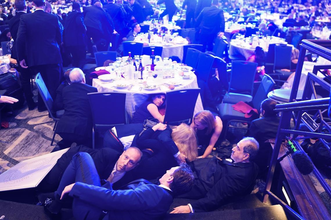 Guests take cover after an unknown safety event took place at the White House Correspondents Association Dinner on April 25.