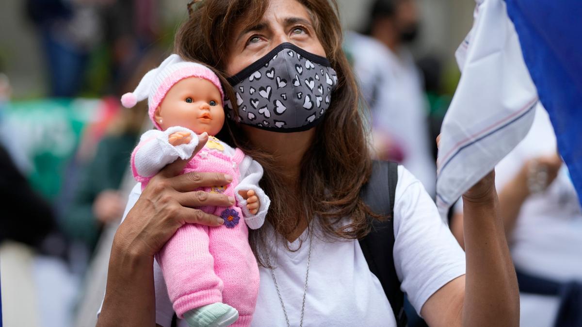 Un activista contra el aborto sostiene una muñeca durante una protesta frente a la Corte Constitucional mientras los jueces continúan las discusiones sobre la despenalización del aborto en Bogotá, Colombia, el lunes 21 de febrero de 2022. (AP Foto/Fernando Vergara)
