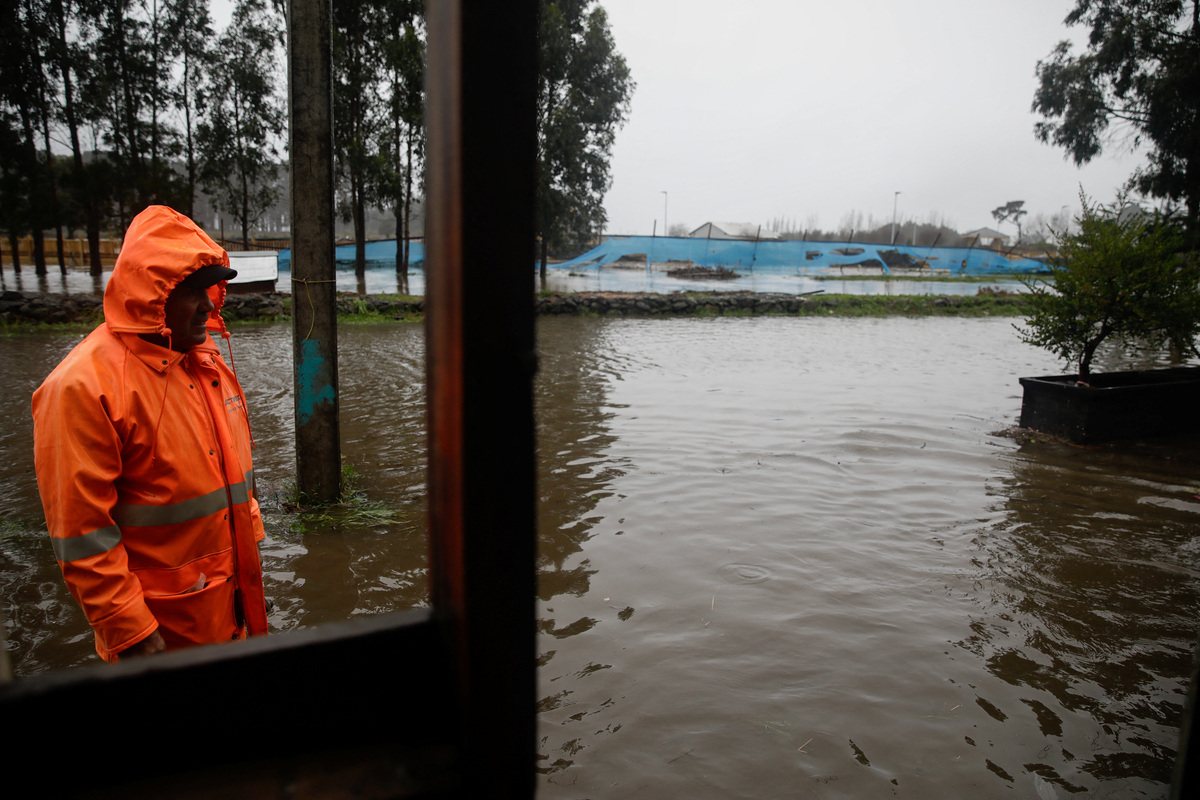 A resident looks at floodwater by their home, after heavy rain fall during a weather front caused flooding, and led the Chilean authorities to declare a preventive state of emergency at the start of the week, in Arauco, Chile, July 16, 2026. REUTERS/Juan Gonzalez