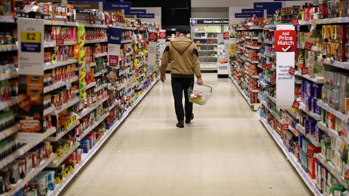FILE PHOTO: A shopper walks along an aisle inside a Tesco supermarket in Manchester, Britain, February 5, 2026 REUTERS/Phil Noble/File Photo