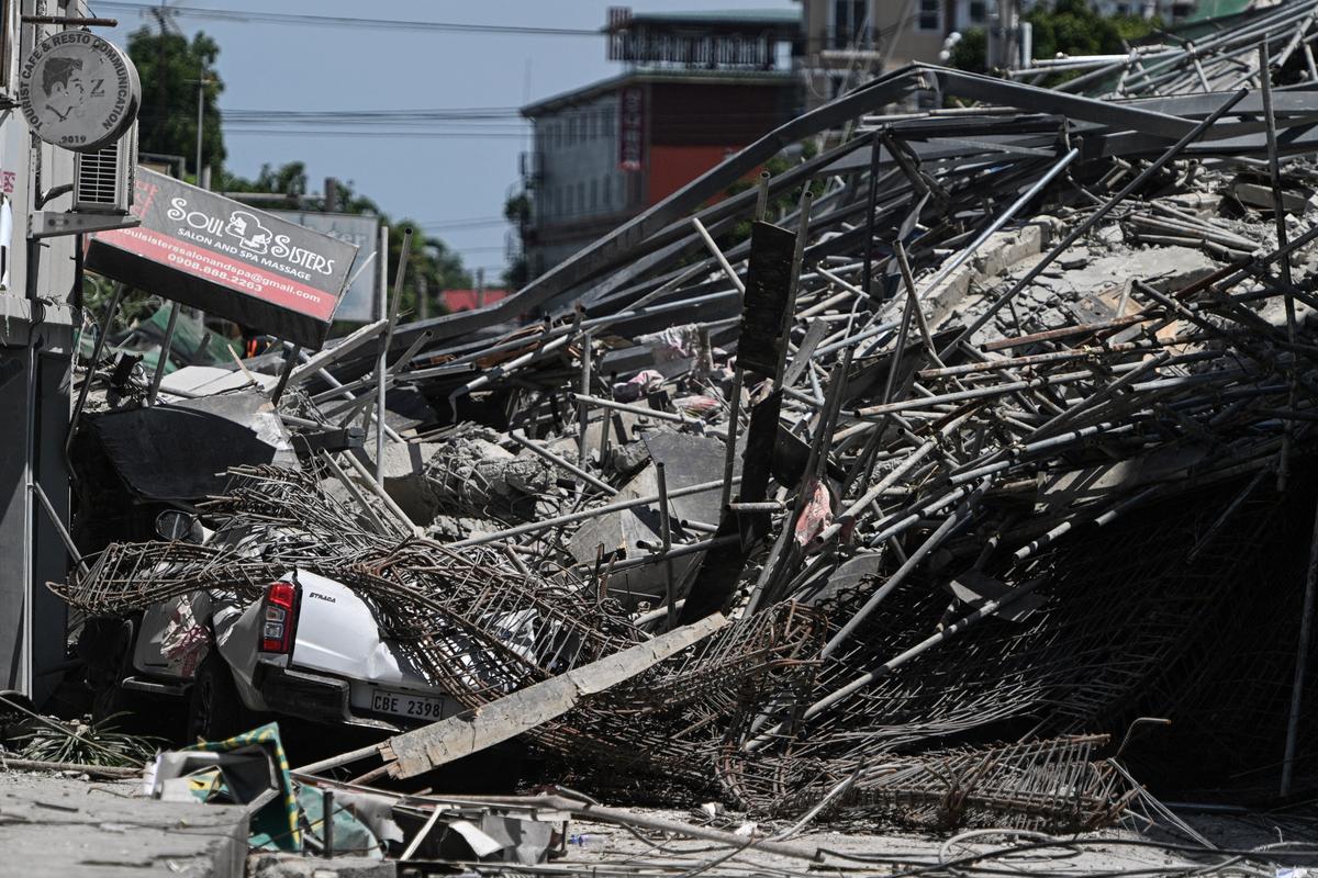 A car lies crushed under the debris as a nine-story building under construction collapsed in Balibago, Angeles City, Pampanga, Philippines, May 24, 2026. REUTERS/Noel Celis