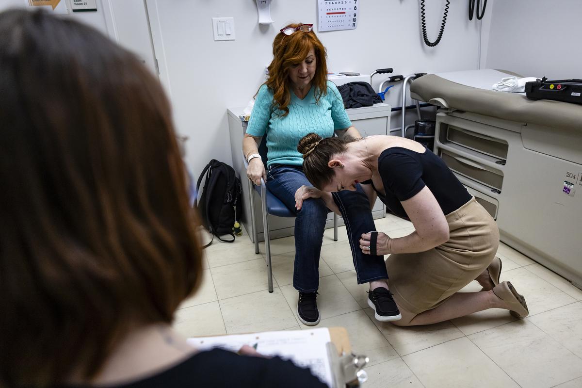 Anne-Laure Grignon, a senior project manager for ALS research at the University of Miami, tests Amanda Sifford's leg strength at the University of Miami Health System, in Miami on Jan. 9, 2026. The drug, tofersen, made by Biogen and marketed as Qalsody, is for a small subset of patients. But evidence that breathing and strength can get better for some of them is remarkable for a paralyzing, usually fatal disease. (Eva Marie Uzcategui/The New York Times)