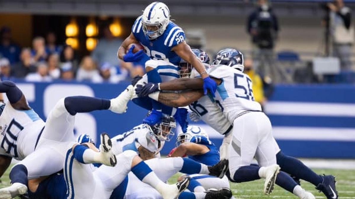 Indianapolis Colts running back Jonathan Taylor (28) runs the ball while Tennessee Titans linebackers Harold Landry (58) and Monty Rice (56) defend. Mandatory Credit: Trevor Ruszkowski-USA TODAY