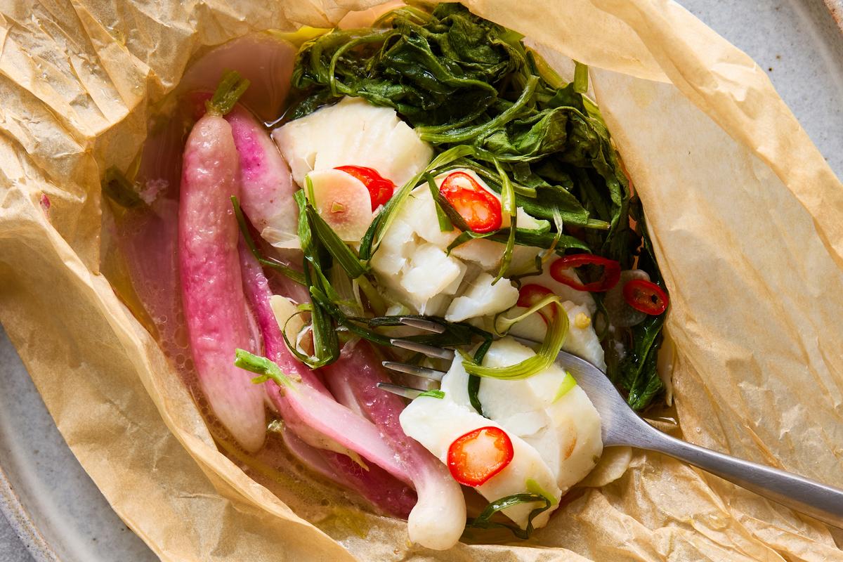 Parchment-steamed fish with buttered radishes. Aromatic parcels of spoon-tender white fish fillets, sweet steamed radishes and peppery greens are a delight to unwrap. Food styled by Brett Regot. (Ghazalle Badiozamani/The New York Times)
