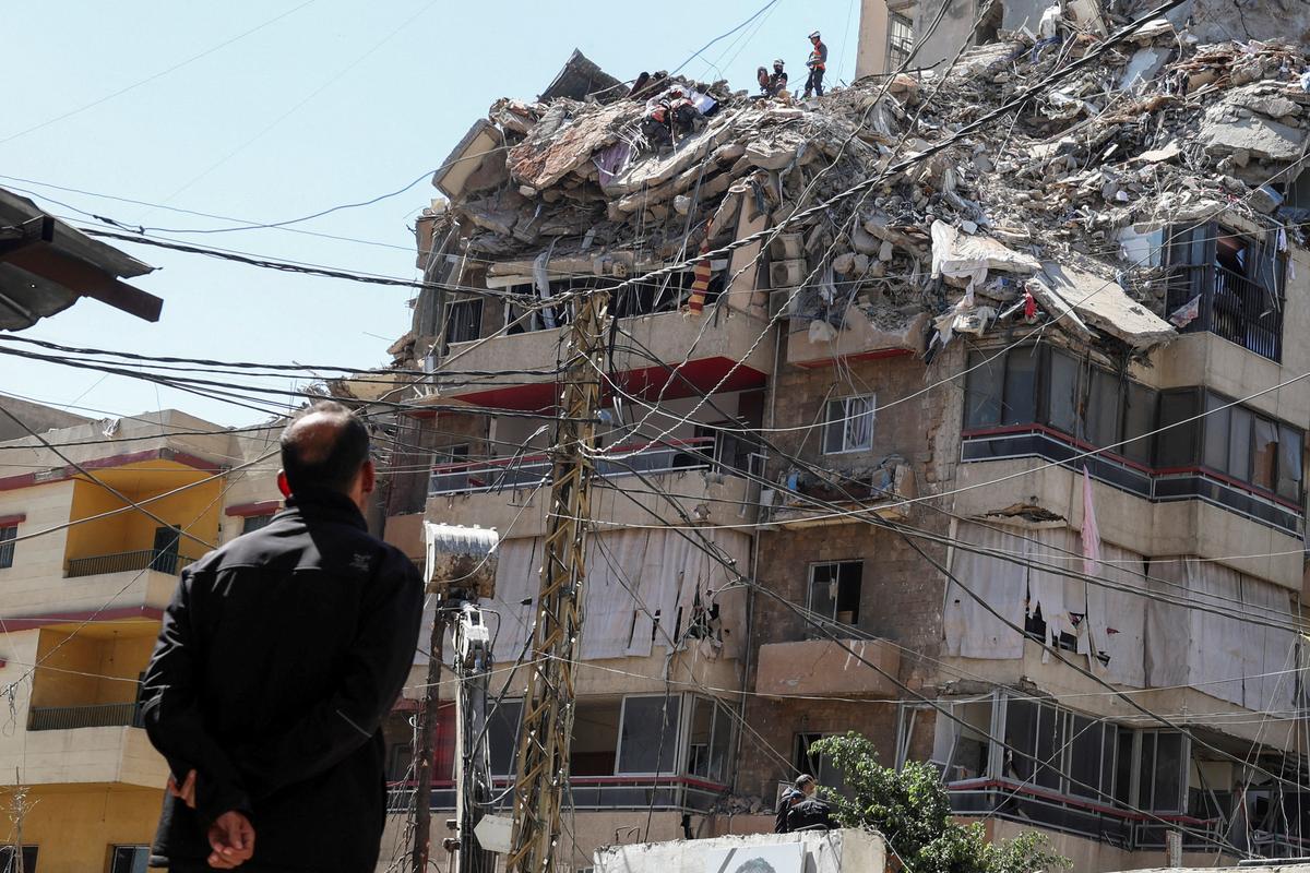 A man watches as rescuers work at the site of an Israeli strike that took place yesterday, in the southern suburbs of Beirut, Lebanon, May 7, 2026. REUTERS/Mohamad Azakir
