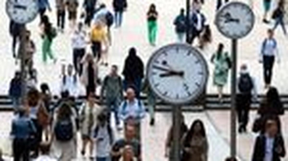 FILE PHOTO: Workers walk through the Canary Wharf financial district, in London, Britain, August 3, 2023. REUTERS/Toby Melville/File Photo