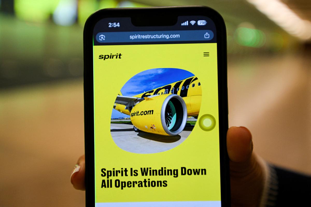 A mobile phone displays a Spirit Airlines operational update website, as the airline announced it was ceasing operations early Saturday morning following an impasse in talks with some creditors on a $500 million government bailout plan, at Orlando International Airport in Orlando, Florida, U.S., May 2, 2026. REUTERS/Miguel Rodriguez
