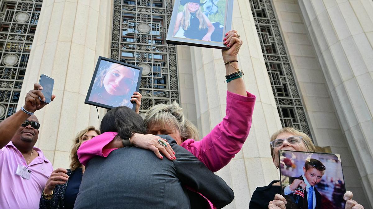 Relatives of victims, including Lori Schott, middle, walk out of the Los Angeles Superior Court holding portraits of their loved ones in Los Angeles, on Wednesday, March 25, 2026. (Frederic J. Brown/AFP/Getty Images/TNS)