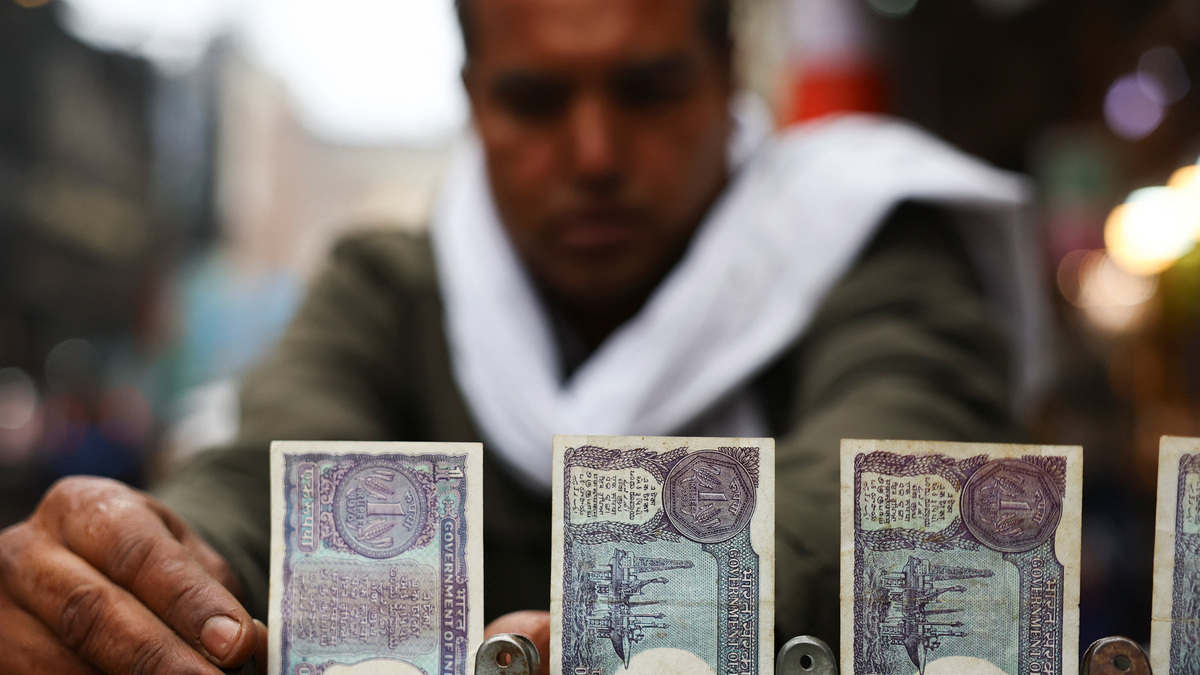 A man arranges notes of one rupee of Indian currency at a roadside currency exchange stall in the old quarters of Delhi, India, February 2, 2026. REUTERS/Anushree Fadnavis