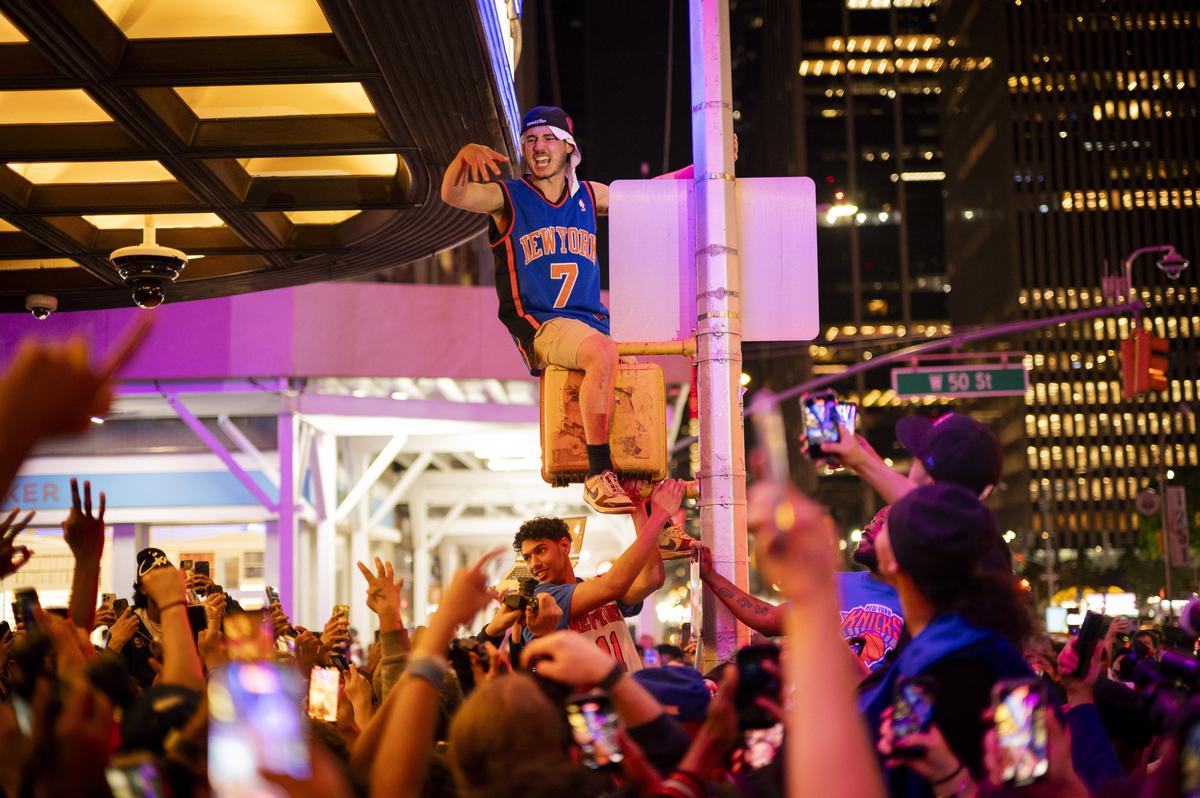 Jubilant Knicks fans celebrate outside Madison Square Garden in New York after their team swept the Cleveland Cavaliers in the Eastern Conference Finals to advance to the NBA Finals for the first time since 1999 on Monday night, May 25, 2026. Thousands of fans blocked traffic outside Madison Square Garden, even though the game was in Ohio and the outdoor watch parties at the Garden had been suspended because of rowdy fans. (Vincent Alban/The New York Times)