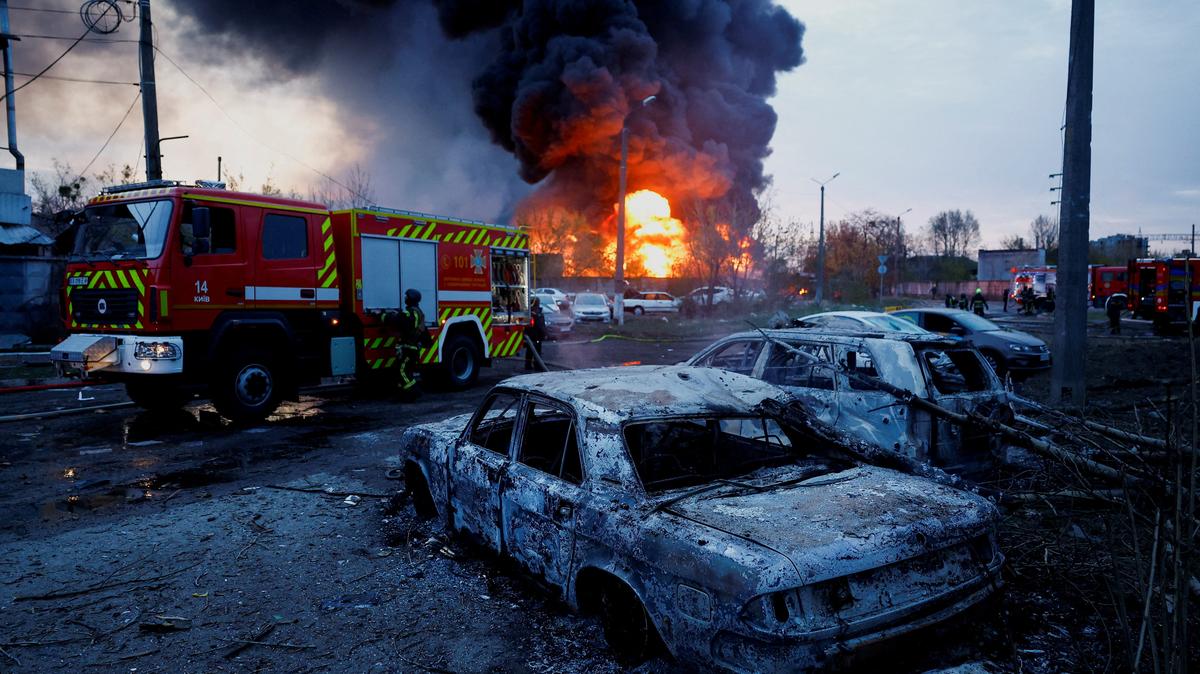 Firefighters work next to destroyed vehicles, at the site of a Russian missile strike, amid Russia's attack on Ukraine, in Kyiv, Ukraine, April 16, 2026. REUTERS/Valentyn Ogirenko