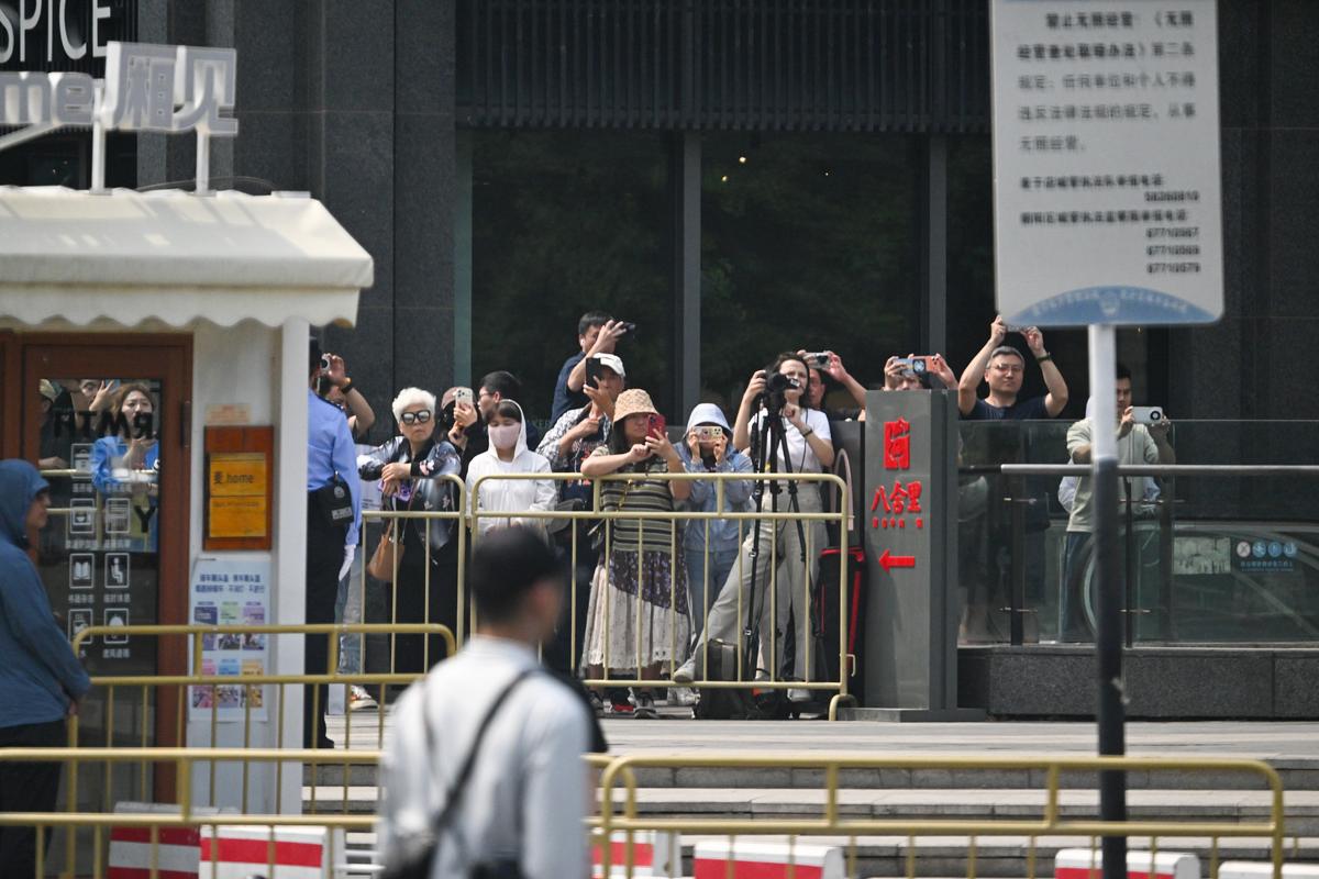 People photograph President Donald Trump's motorcade as the American leader departed the Temple of Heaven in Beijing during a two-day summit with President Xi Jinping of China, on Thursday, May 14, 2026. During the first U.S. presidential visit to China in nearly a decade, Xi delivered a warning on Taiwan, saying that the issue, if handled poorly, could lead to conflict and "an extremely dangerous situation." (Kenny Holston/The New York Times)..